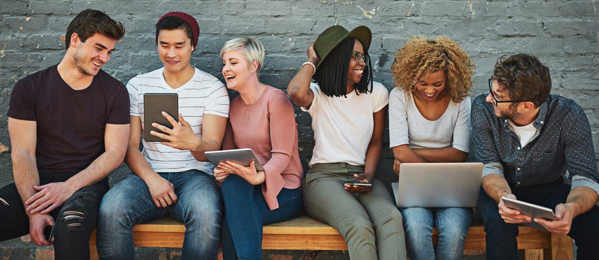 A diverse group of young adults using their favorite mobile devices and checking their MeMail accounts.